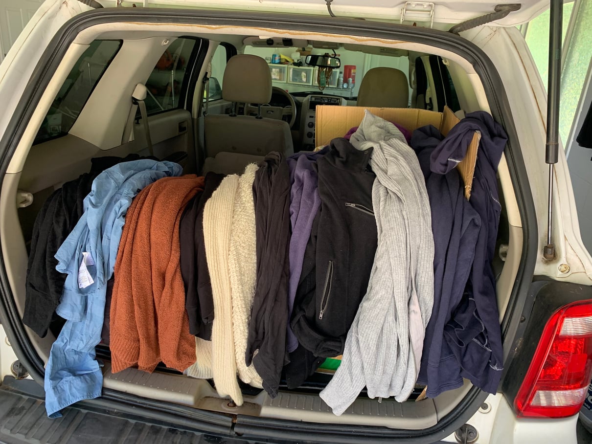 Blankets and clothing arranged in the back of a vehicle