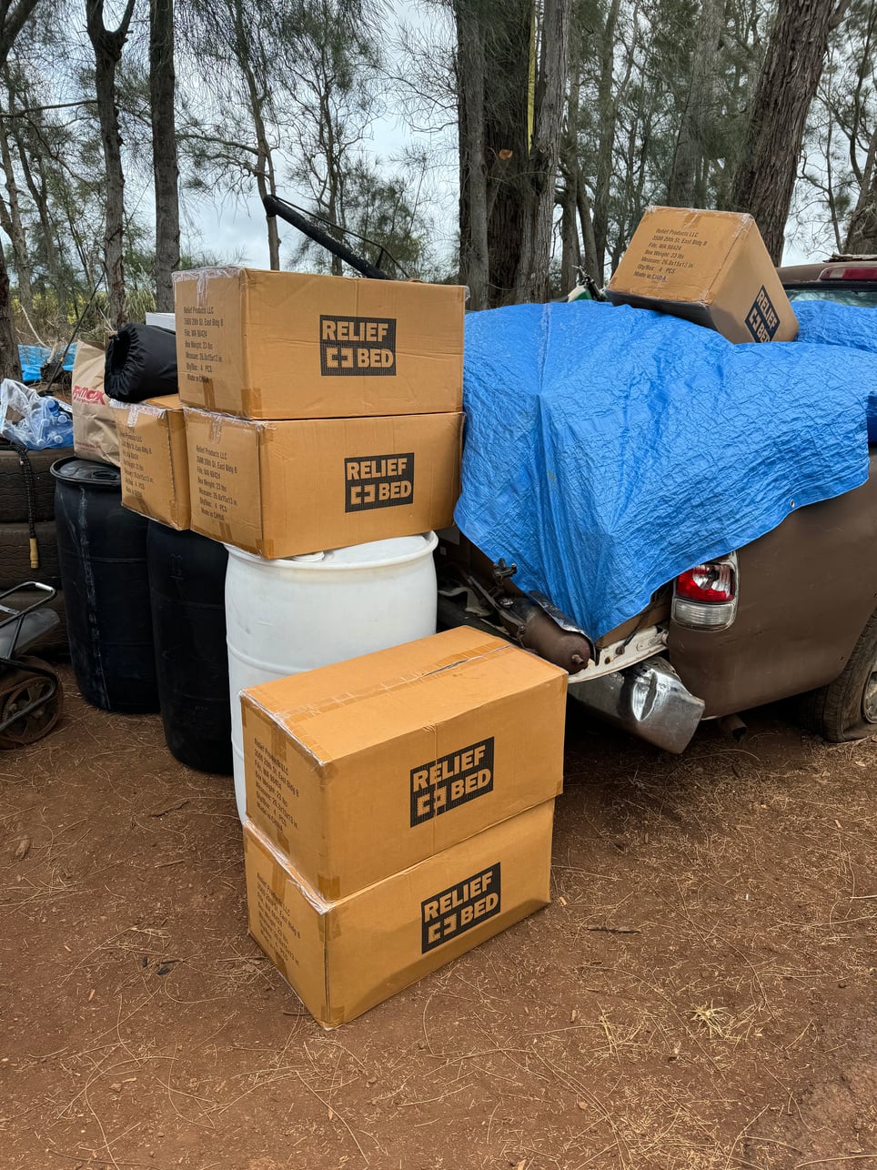 Boxes of Relief Bed portable beds delivered beside community supplies
