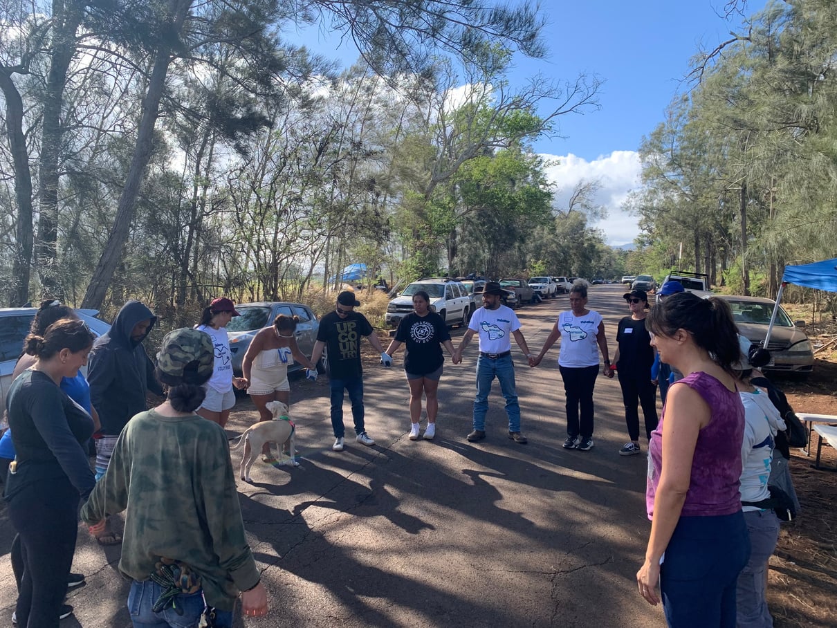 Holomua Outreach volunteers standing in a circle together before community work begins