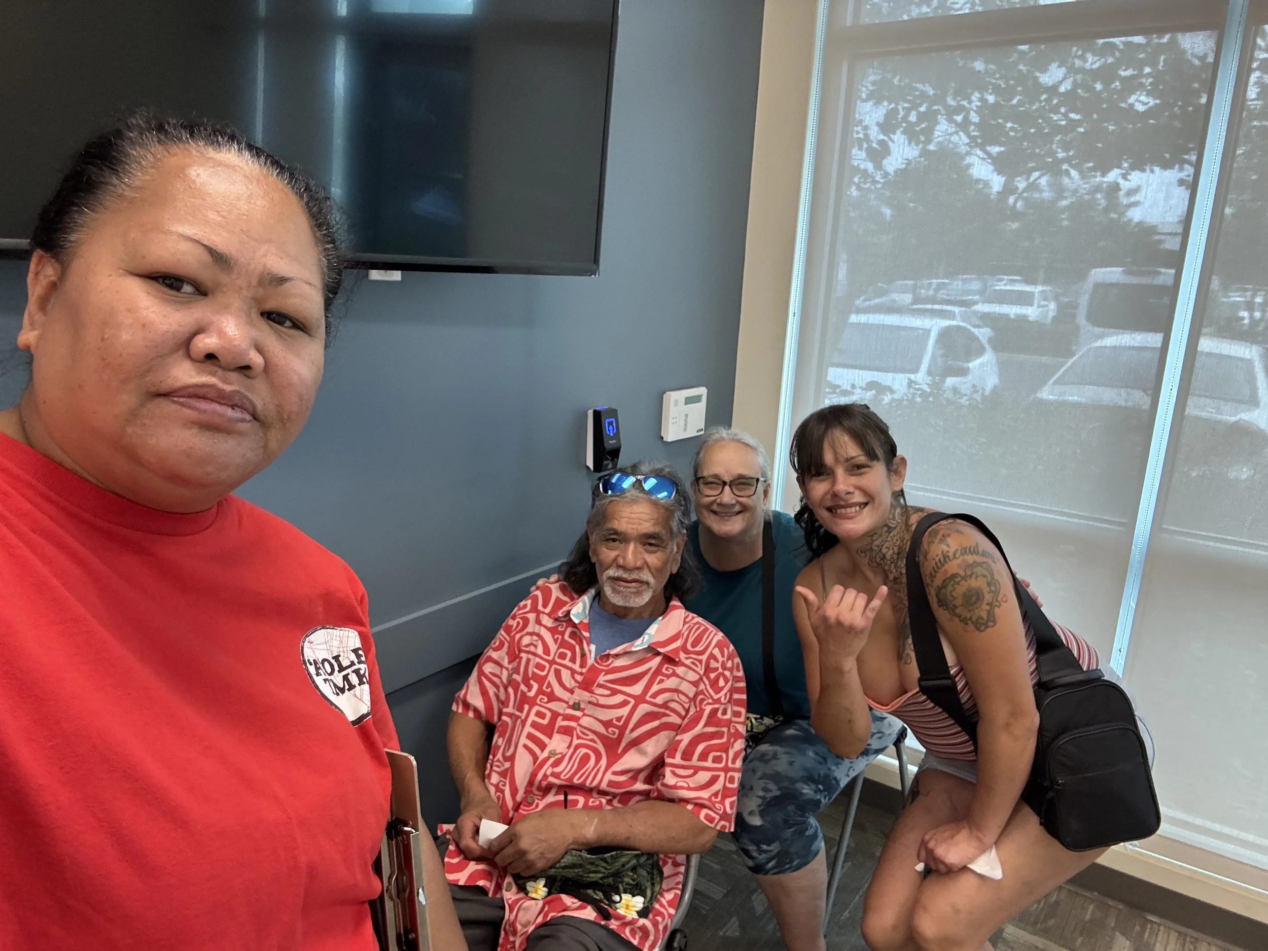 Moʻi Kawaakoa standing indoors with community members