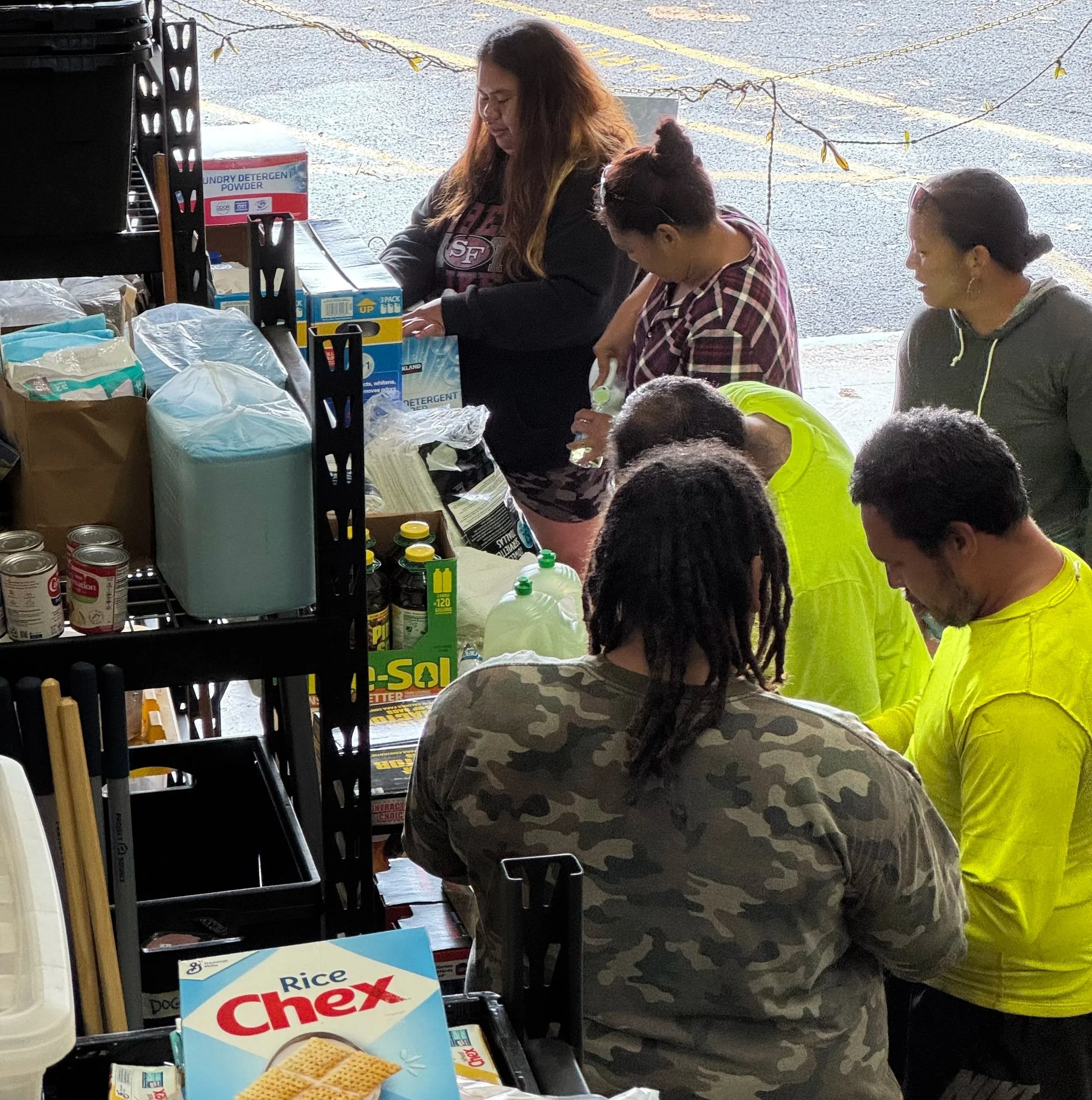 Community members organizing donated food, hygiene products, and household supplies