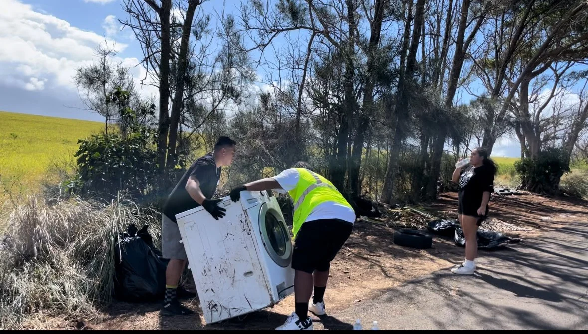 Community members removing a discarded washing machine from the roadside